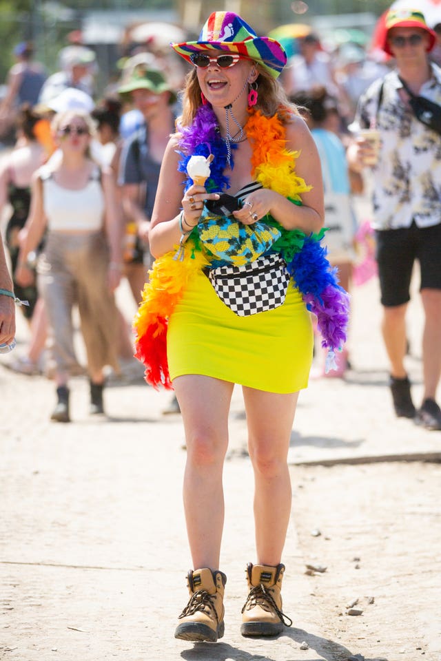 A festival-goer eats an ice cream to cool off