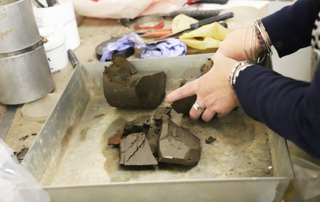 An archaeologist breaking a soil sample
