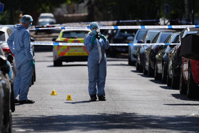 Police officers in forensic suits at the scene outside Lopez House on Willington Road in Clapham, south London, after a 25-year-old man was shot dead on Monday evening