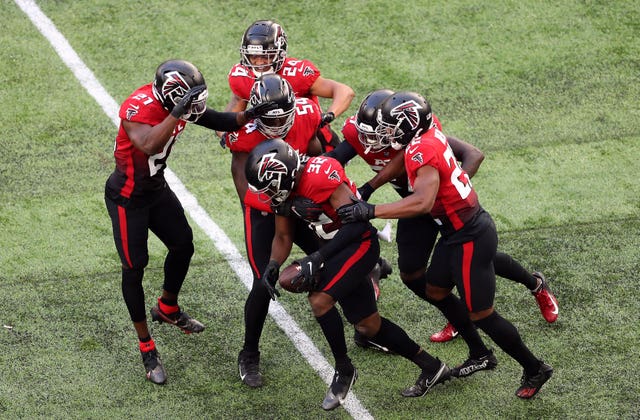 Jaylinn Hawkins, centre, celebrates his interception with his Falcons team-mates