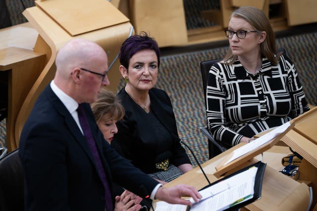 Angela Constance seated in Holyrood, watching John Swinney speaking