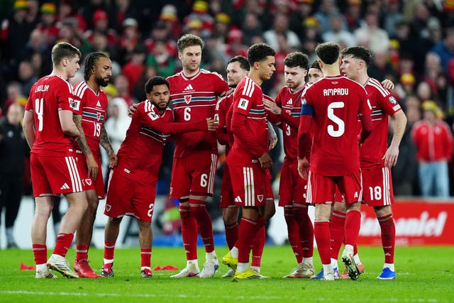 Wales’ Brennan Johnson (centre right) is consoled by team-mates after missing a penalty