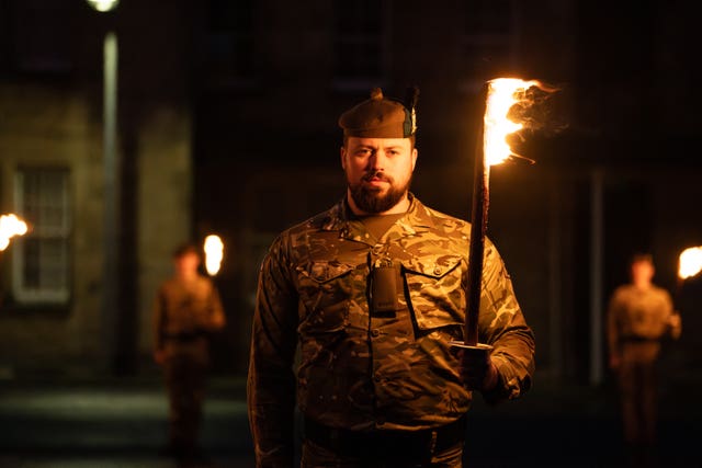 A soldier holding a torch aloft