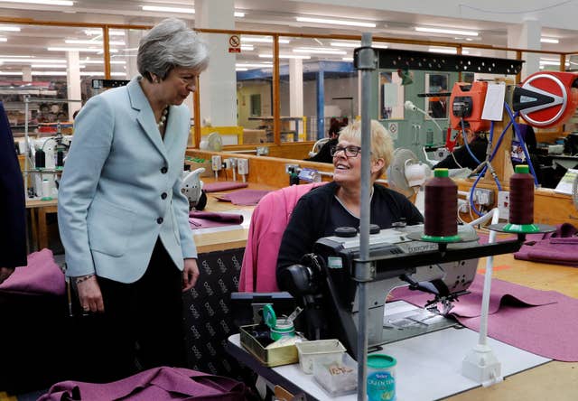Prime Minister Theresa May speaks to a worker during a visit to Boss Design (Darren Staples/PA)