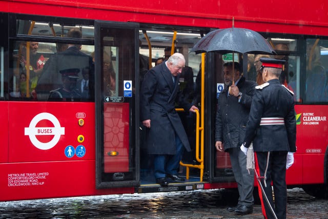 The Prince of Wales steps off an electric bus as he and the Duchess of Cornwall arrive for a tour of the London Transport Museum