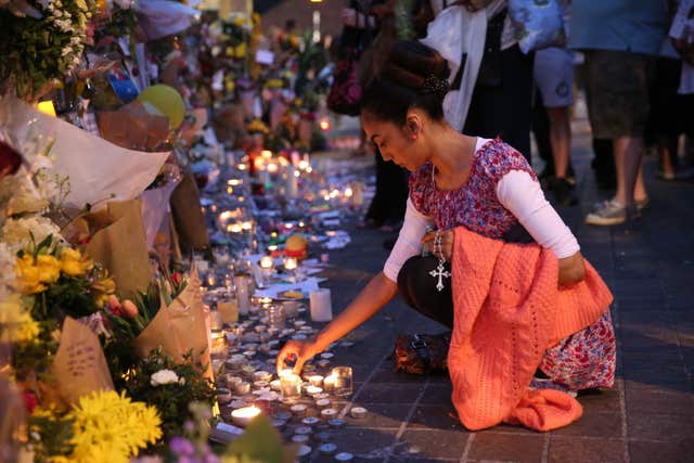 People look at tributes and light candles at Notting Hill Methodist Church near Grenfell Tower (Isabel Infantes/PA)