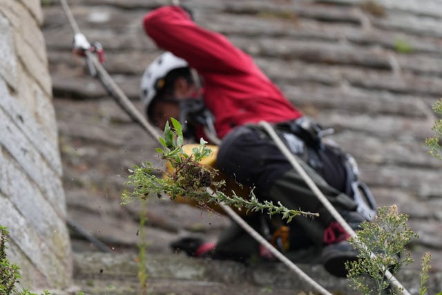 A person cleaning a wall at Warwick Castle