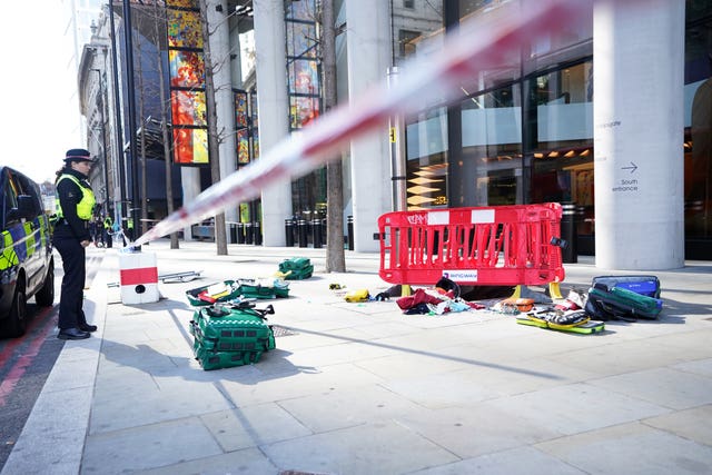 A police officer looks at medical equipment at the scene after three people have been taken to hospital following reports of stabbings at Bishopsgate in London
