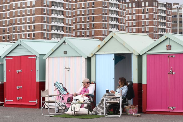 Ladies enjoy a beach hut at Brighton beach, East Sussex
