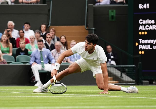 Carlos Alcaraz slides to hit the ball