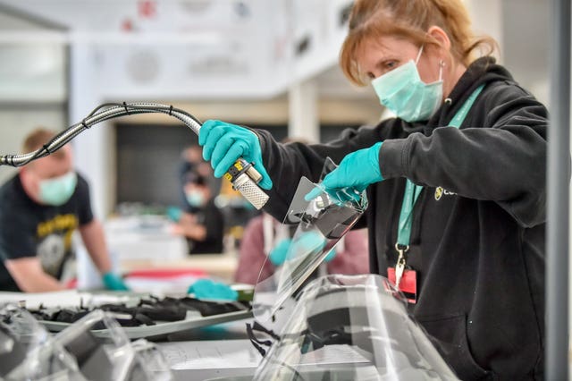 Royal Mint employees assemble full face visors in the cafe inside the Royal Mint Experience (Ben Birchall/PA)