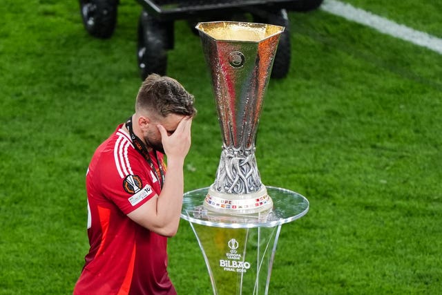 Manchester United’s Luke Shaw looks dejected as he walks past the Europa League trophy