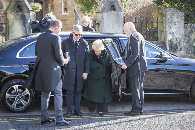 Widow Shirley Devine (centre) arrives for the ceremony