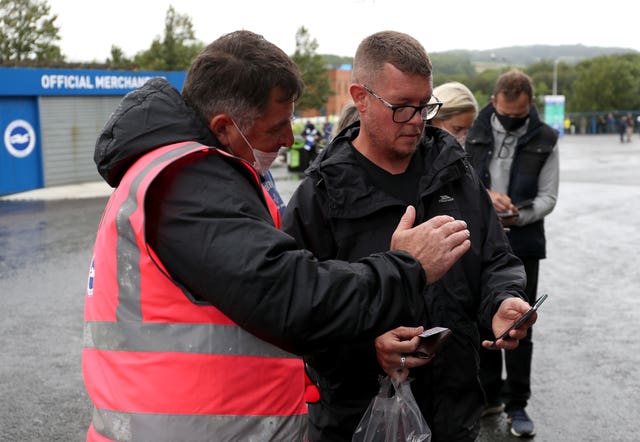 A steward checks a fan's Covid-19 pass before the friendly between Brighton and Getafe at the Amex Stadium (Kieran Cleeves/PA).