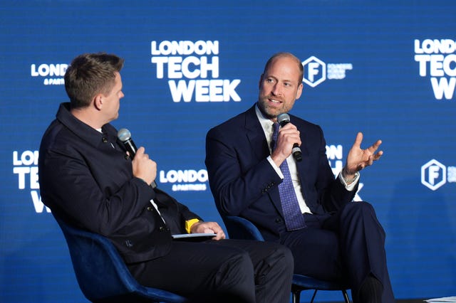 The Prince of Wales speaking into a microphone on a stage, with Tech Week signage behind him
