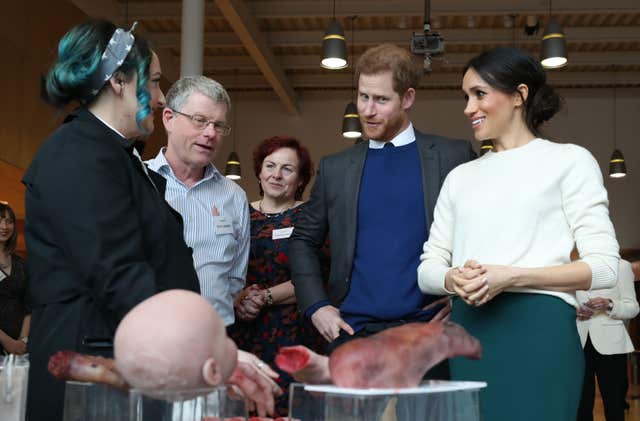 Nuala Campbell and Eoin Lambkin from Titanic FX show Prince Harry and Meghan Markle some prosthetic limbs used in the movie industry (Niall Carson/PA)