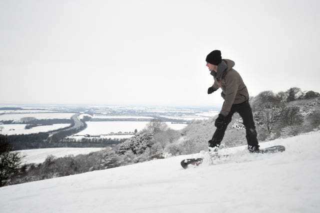 A person snowboards in Aston Rowant National Nature Reserve on the Chilterns escarpment, in Oxfordshire