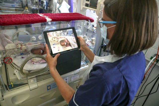 A nurse making a video of a newborn baby