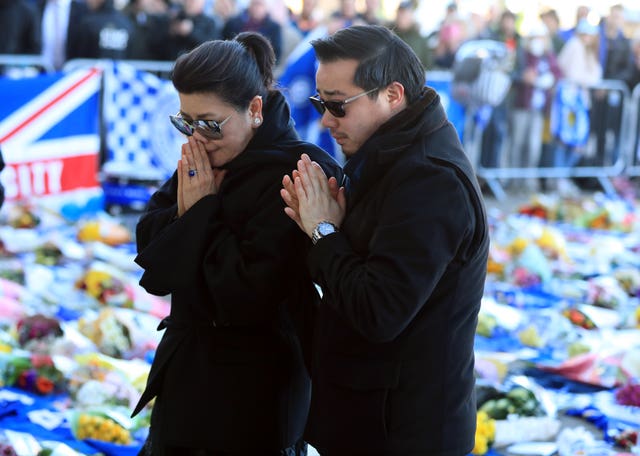 Aiyawatt Srivaddhanaprabha lays a wreath in memory of his father with his mother Aimon (Mike Egerton/PA)
