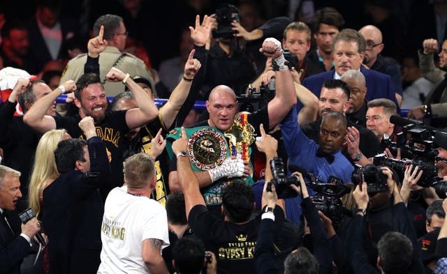 Tyson Fury (centre) got his hands on the belt 