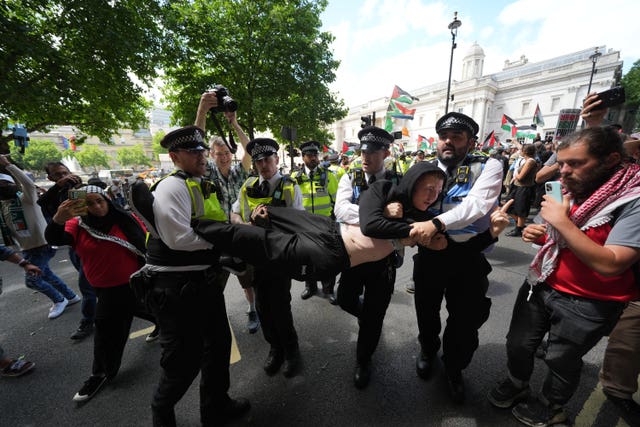 Police remove a person taking part in a demonstration at Trafalgar Square in support of Palestine Action
