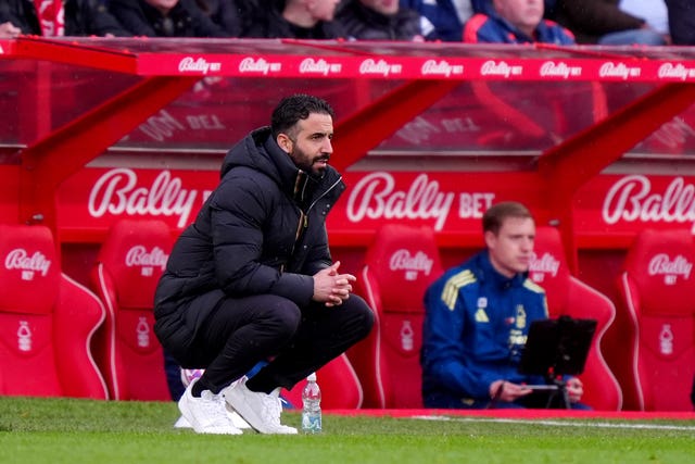 Ruben Amorim crouches next to the dugout
