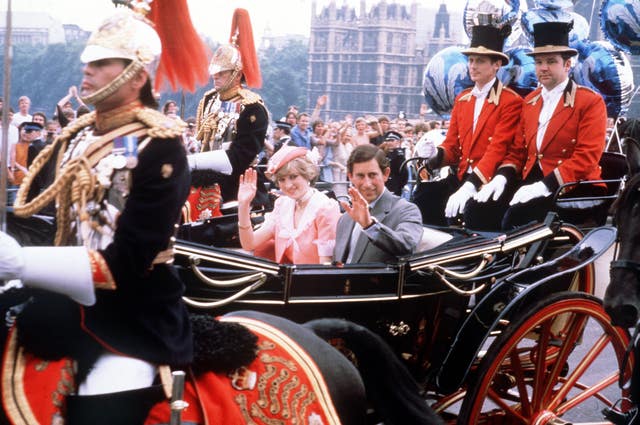 The newly married Prince and Princess of Wale wave to the London crowds from their open-top carriage as they make their way to Waterloo Station to depart for their honeymoon (PA)