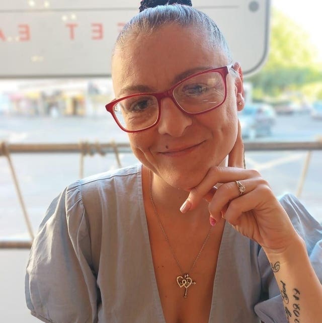 Handout photo of Lisa Holland smiling, with one hand resting on her face