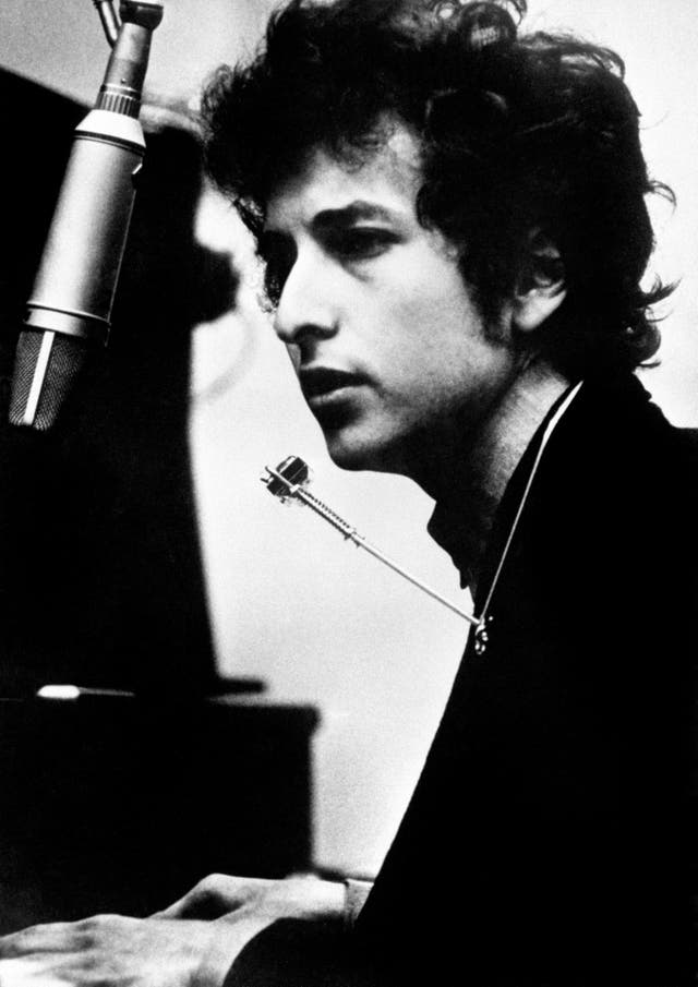 Singer Bob Dylan at his piano in black and white