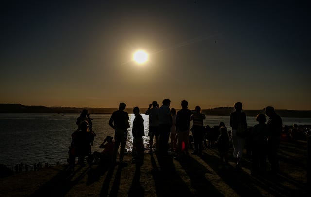 Crowds watch the partial solar eclipse over St Mawes Castle in Cornwall