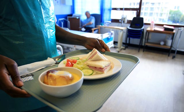 A woman carrying a meal for a hospital patient
