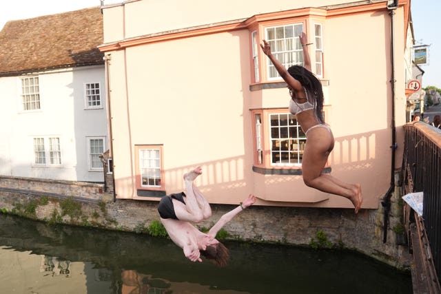 A male and female jumping into the River Cam