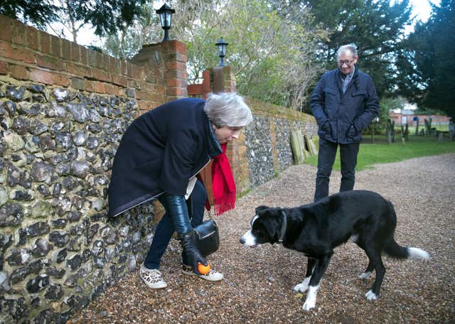 Theresa May, watched by her husband Philip, throws a ball for a Border Collie called Blitz (Steve Parsons/PA)