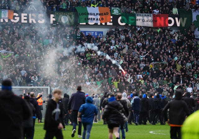 Fans invading the pitch at Ibrox, with Celtic supporters in the stands in the background