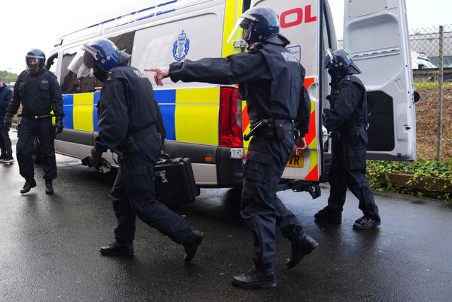 Police officers in protective helmets outside a police van
