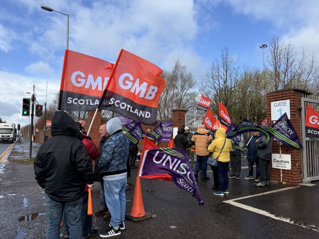 Union members on a picket line, holding flags