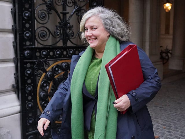 Heidi Alexander smiling while walking, with her ministerial folder under her arm