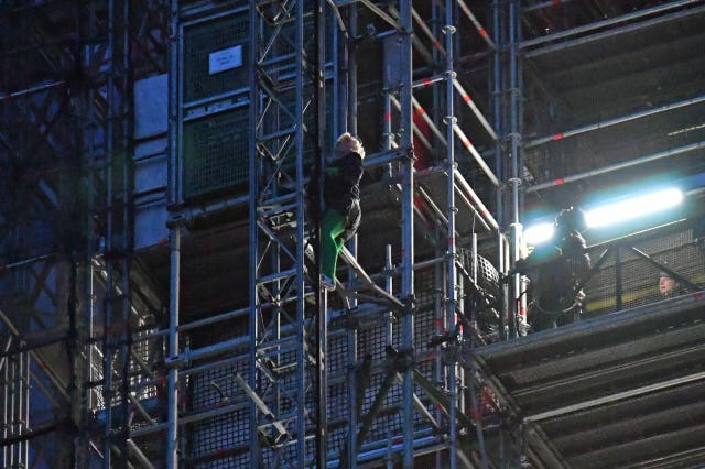 An Extinction Rebellion protester who has scaled the scaffolding surrounding Big Ben, at the Houses of Parliament, Westminster, London