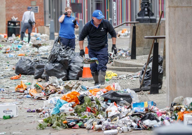 Workers clear litter in the centre of Leeds after celebrations by fans whose football club won the Championship title and a return to the Premier League