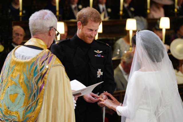 Prince Harry places the wedding ring on Meghan's finger (Jonathan Brady/PA)