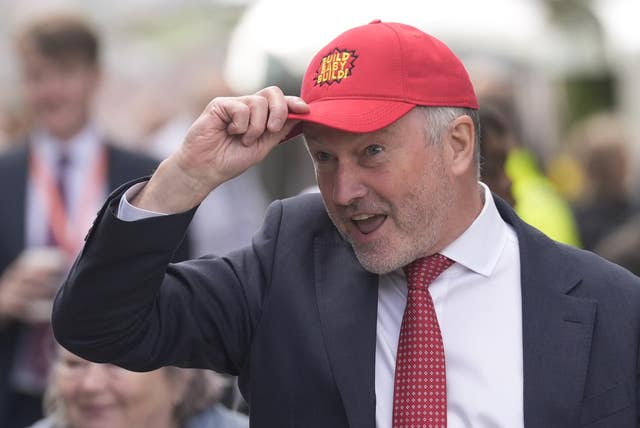 Steve Reed wearing a red 'Build baby build' cap