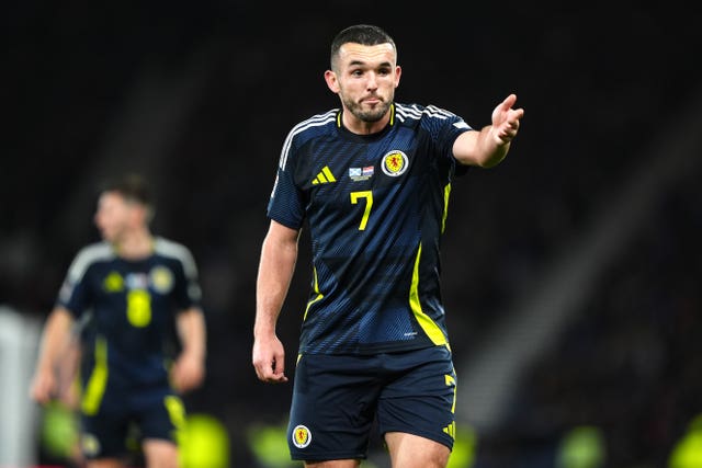 John McGinn gestures with his hand while playing for Scotland