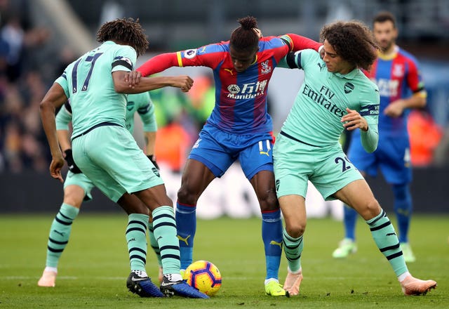 Arsenal’s Alex Iwobi (left) and Matteo Guendouzi (right) battle for the ball with Crystal Palace’s Wilfried Zaha