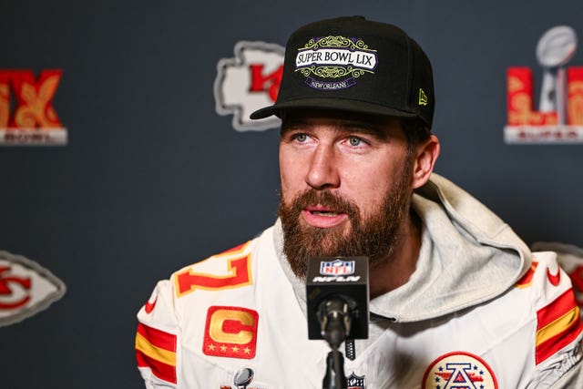 Travis Kelce speaking into a microphone
