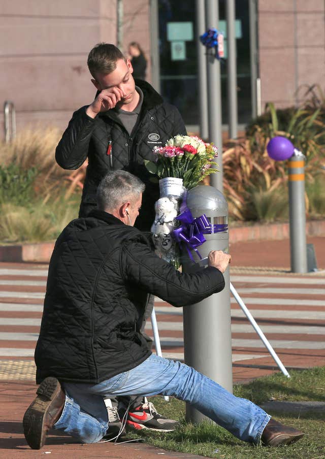 Mourners ties flowers to a post outside the hospital following news of the boy's death (Peter Byrne/PA)