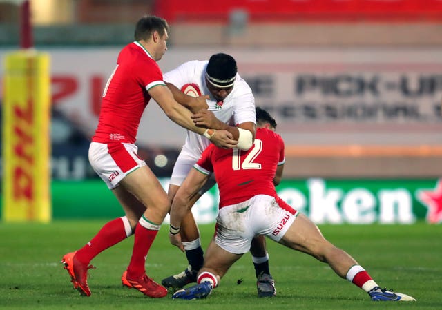 England's Mako Vunipola is tackled by Dan Biggar, left, and Johnny Williams