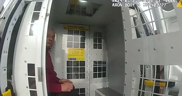 Ahmed Fahmy in the back of a police van