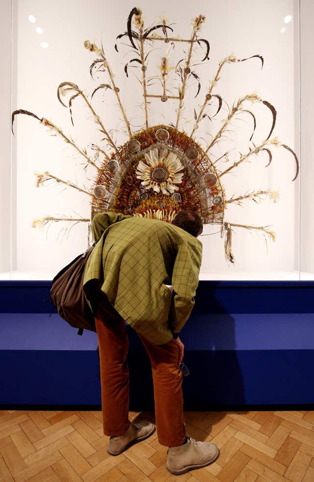 A visitor looks at a headdress created by the Roro people of Yule Island, Papua New Guinea at Oceania at the Royal Academy 