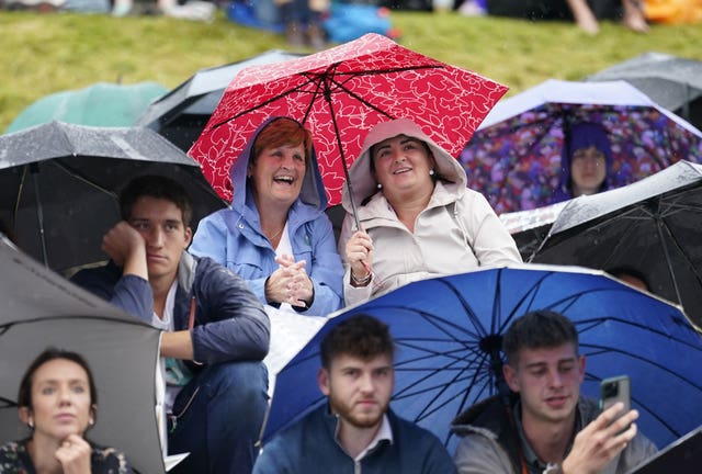 Spectators watching Wimbledon under umbrellas