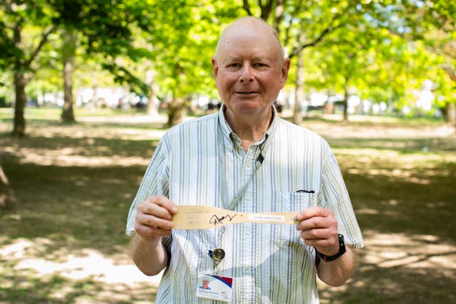 A man holds a wooden spatula